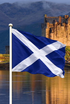 Scotland flag waving in front of a Scottish castle landscape