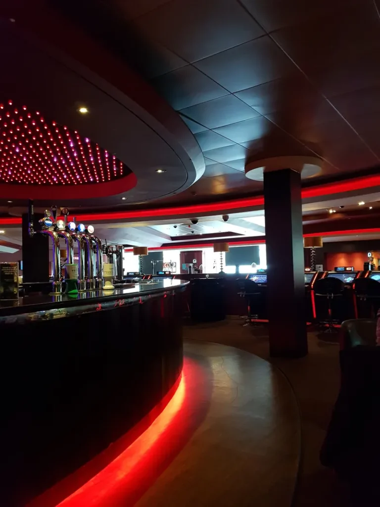 Curved bar with red lighting inside Grosvenor Casino Plymouth