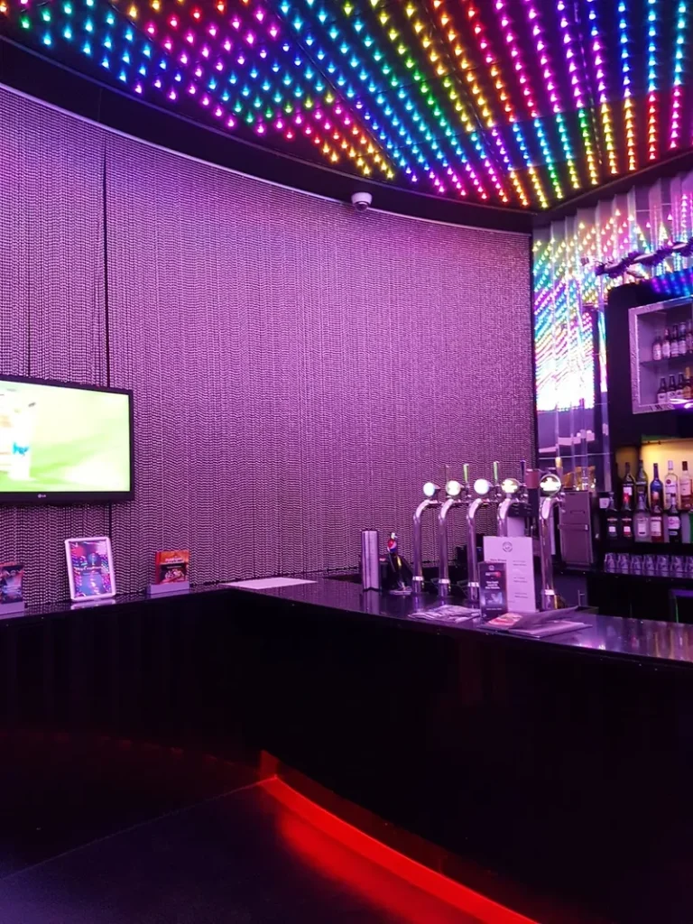 Bar area inside Grosvenor Casino Stockton with colourful ceiling lights`